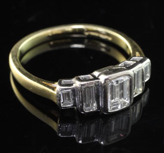 An 18ct gold and collet set graduated emerald cut diamond half hoop ring, size O.